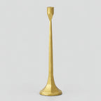 Cast iron taper candle holder in Brass on a light gray studio background.