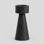 Travertine stone candle holder in Black Travertine on a light gray studio background