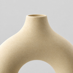Close up of the smooth tapered rim of the beige hollow round ceramic vase.