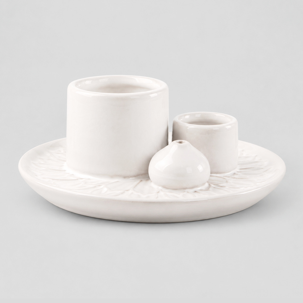 White ceramic incense and candle tray on a light gray studio background