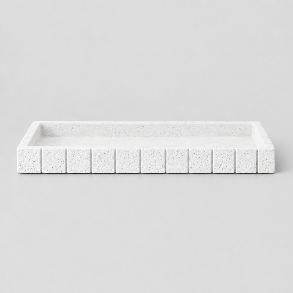 White rectangular fluted travertine vanity tray on a light neutral gray studio background.