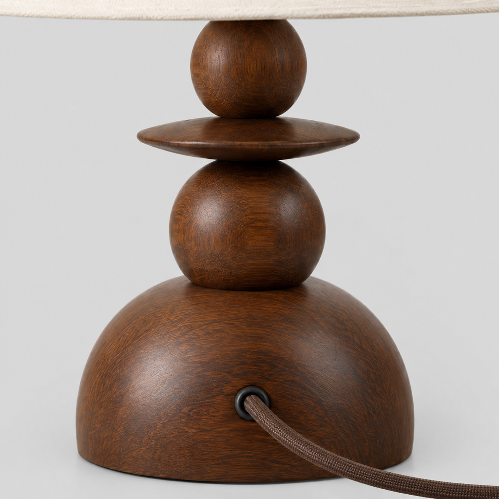 Close up of the cord grip where the cord enters the base of the walnut table lamp.