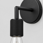 Close up of the arm joint of the Matte Black knurled socket wall sconce
