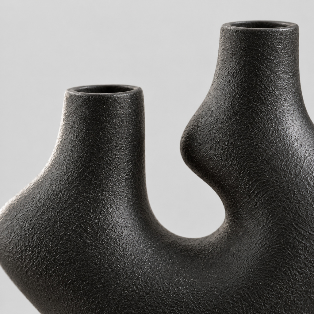 Close up of the granular matte glaze across the contoured ceramic silhouette of the vase