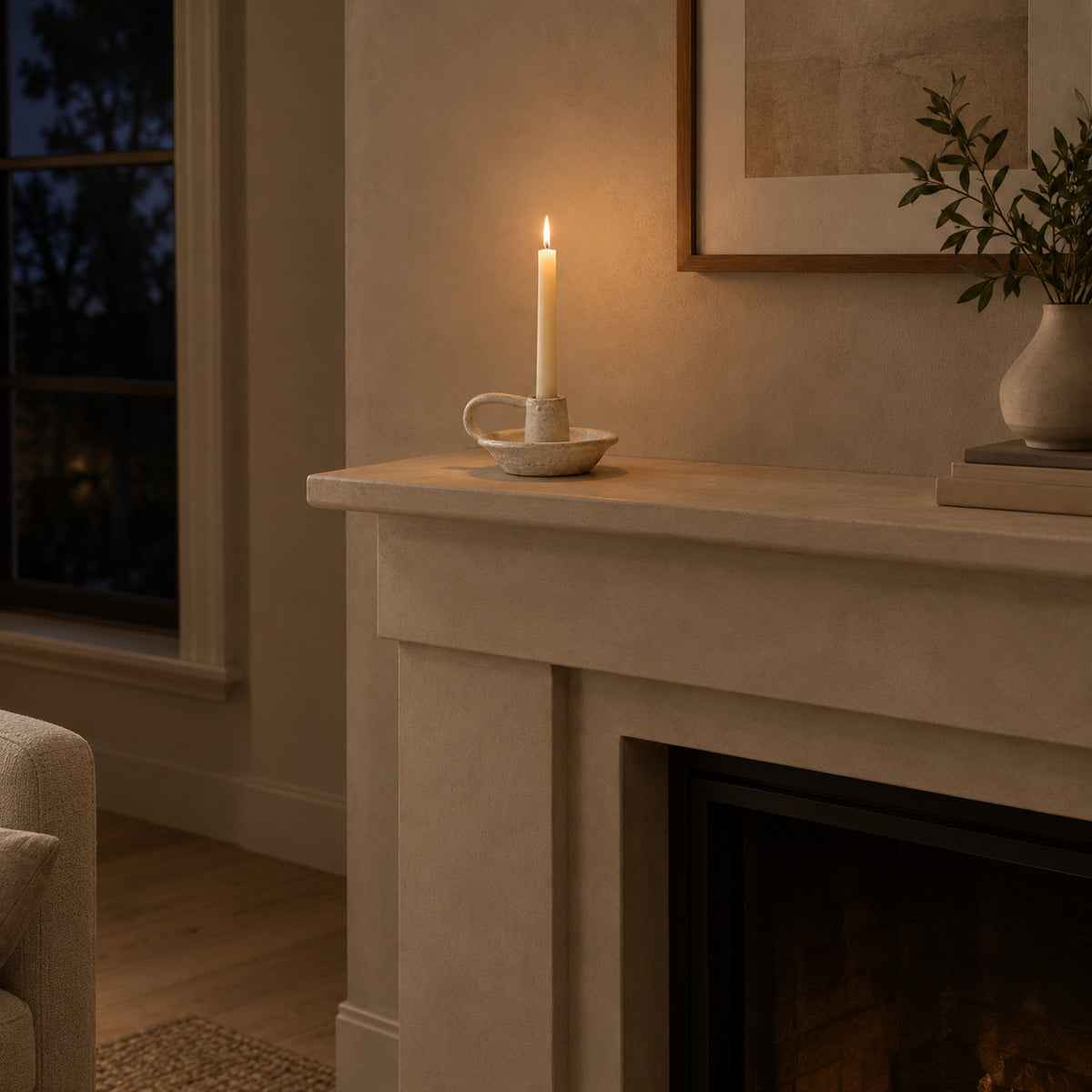 Speckled Off-White ceramic taper candle holder on a 140 cm wide mantelpiece above a fireplace with one lit taper candle in the holder