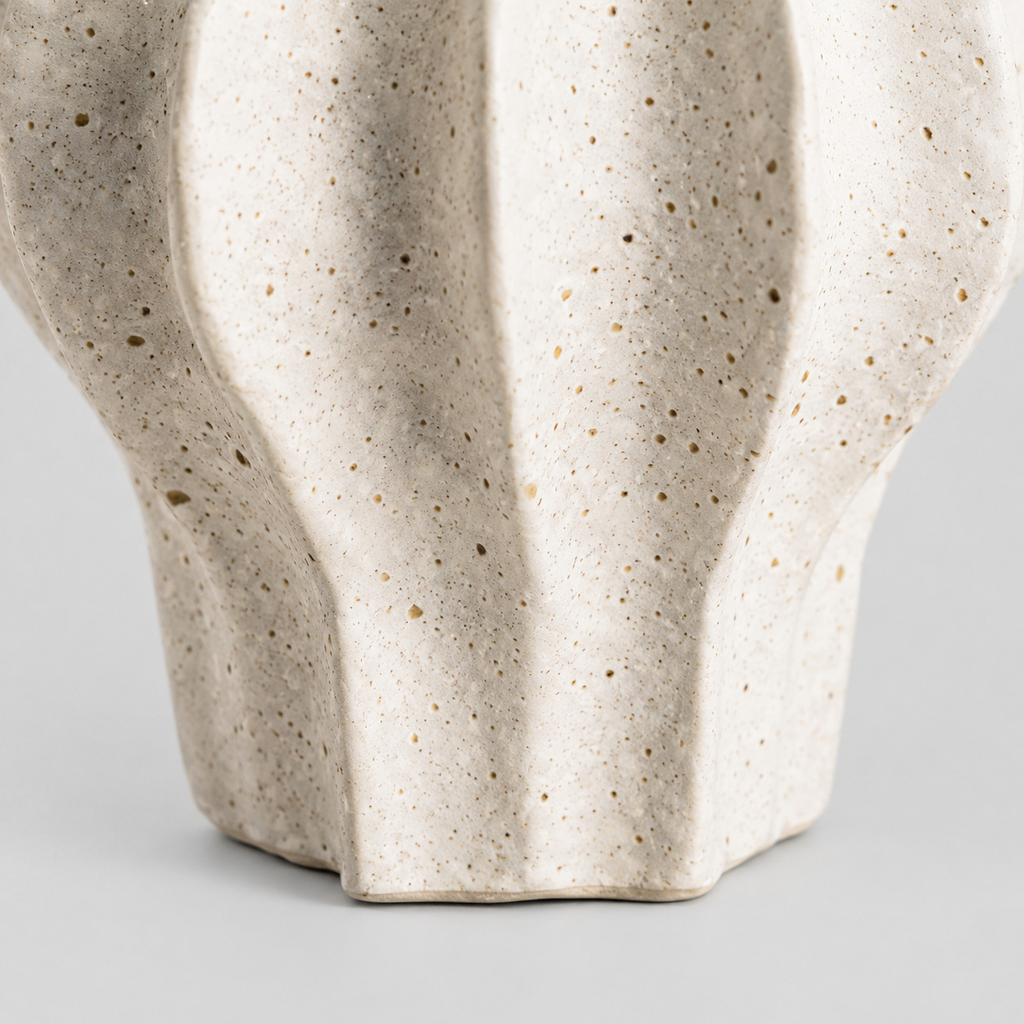 Close up of the unglazed foot of the short fluted ceramic vase.