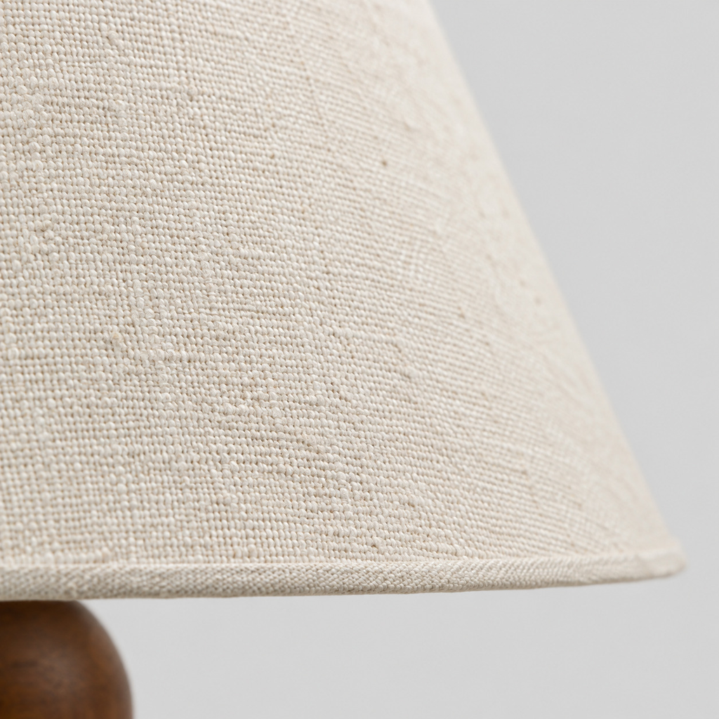 Close up of the weave or fabric texture of the shade on the walnut table lamp.