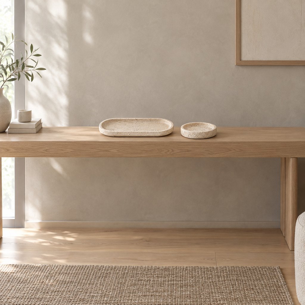 Oval travertine tray on a 120 cm wide oak console table in a calm room.