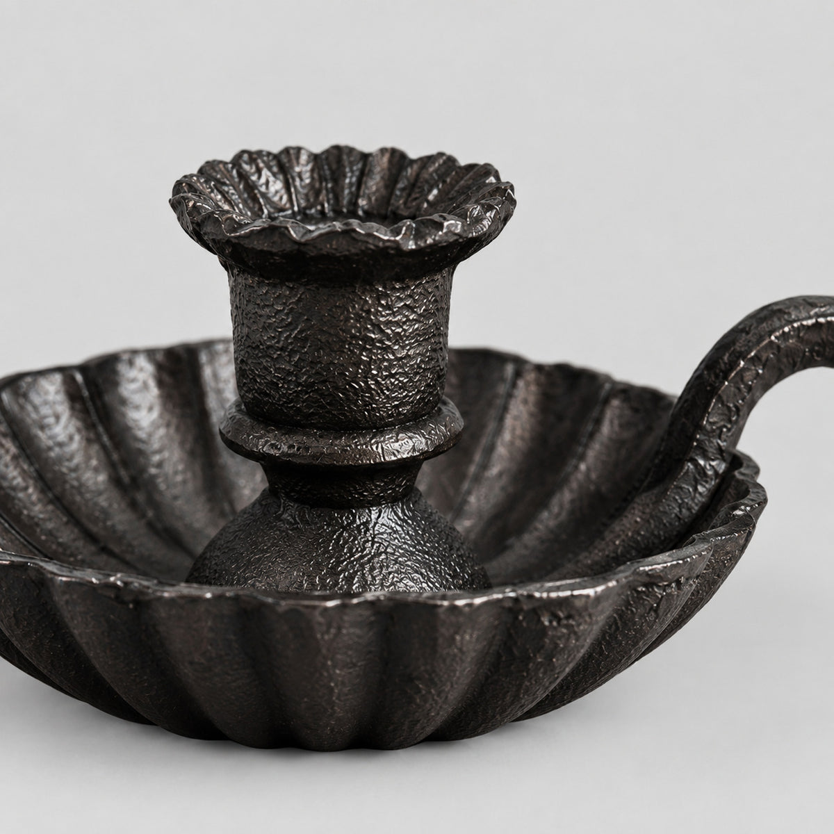 Close up of the fluted saucer base of the chamberstick candle holder.