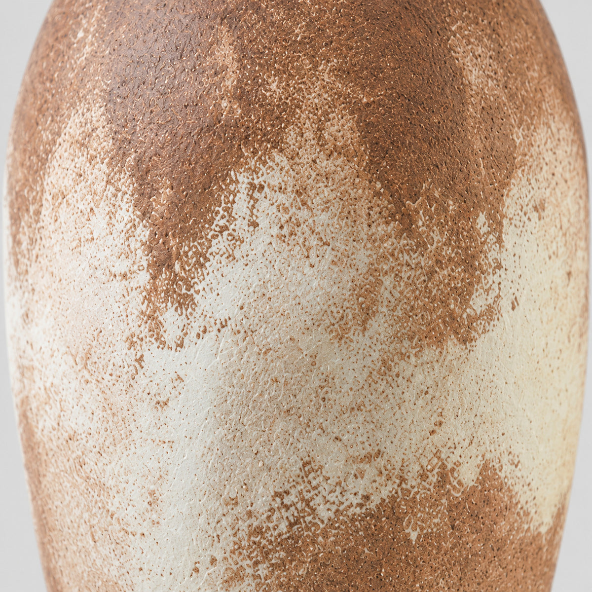 Close up of the weathered mottled glaze on the vase body of the textured ceramic vase.