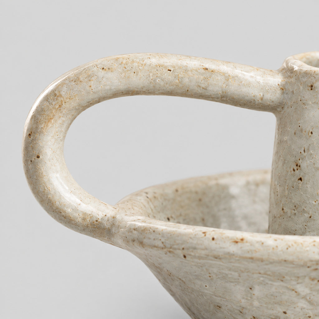 Close up of the curved loop handle of the Speckled Off-White ceramic taper candle holder