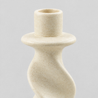 Close up of the speckled matte glaze texture of the beige twisted ceramic taper candle holder.