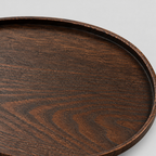 Close up of the ash wood grain texture across the oval dark ash wood serving tray