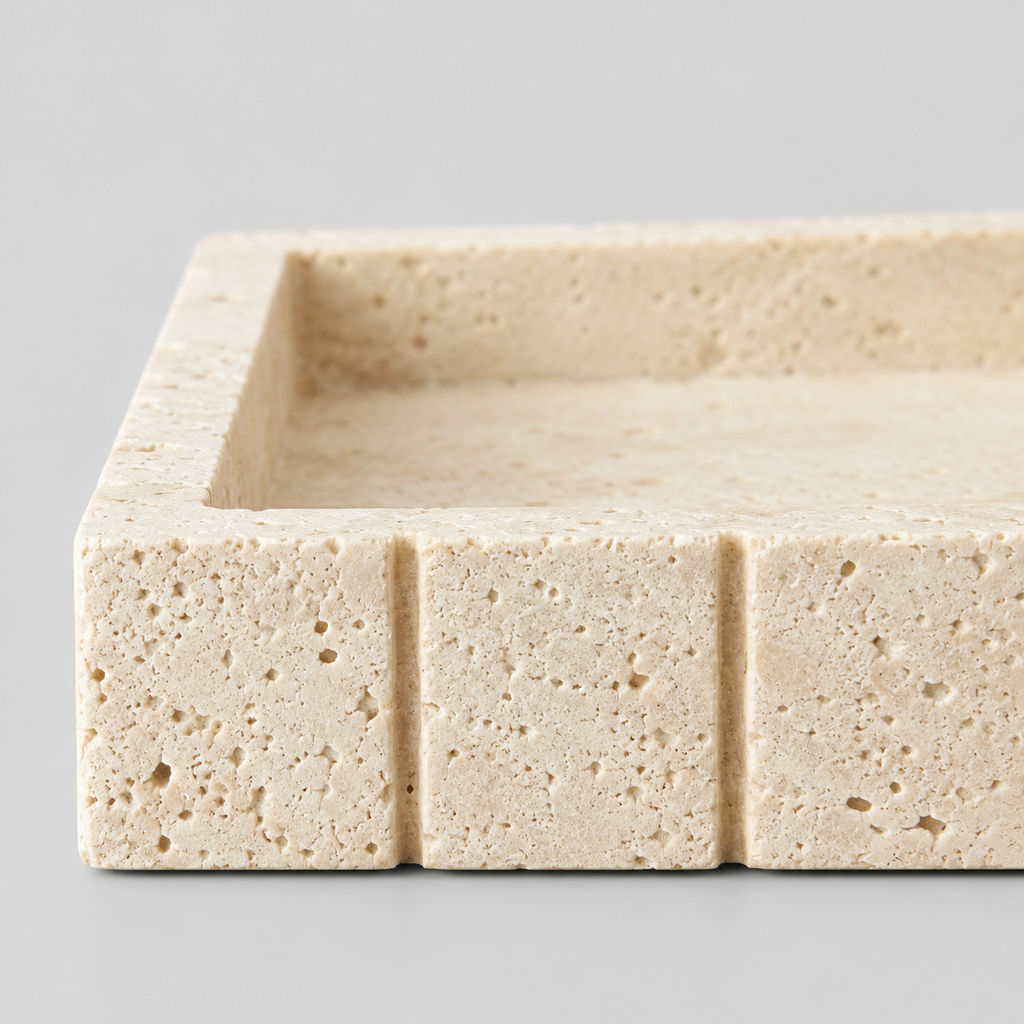 Close up of the porous honed stone surface texture of the beige travertine vanity tray.