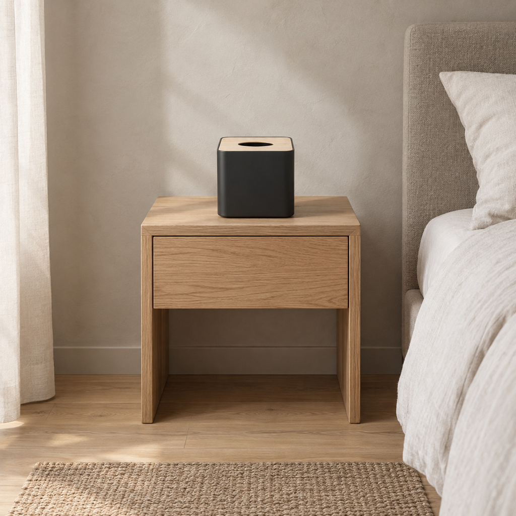 Square tissue box cover in Matte Black on a 48 cm wide oak bedside table in a calm room.