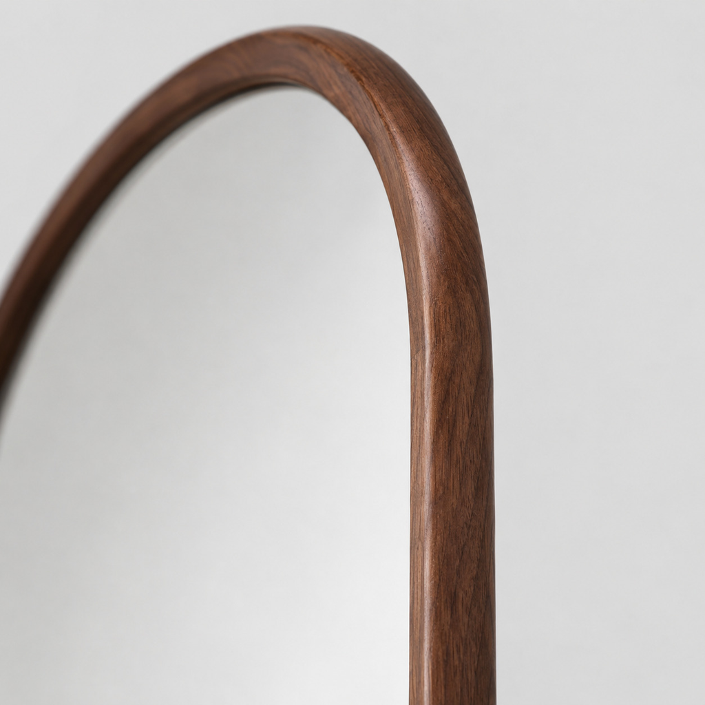 Close up of the natural wood grain along the walnut frame surface of the arched solid wood full-length mirror.