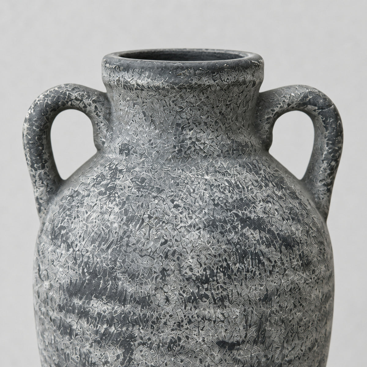 Close up of the distressed textured surface finish of the weathered gray ceramic amphora vase