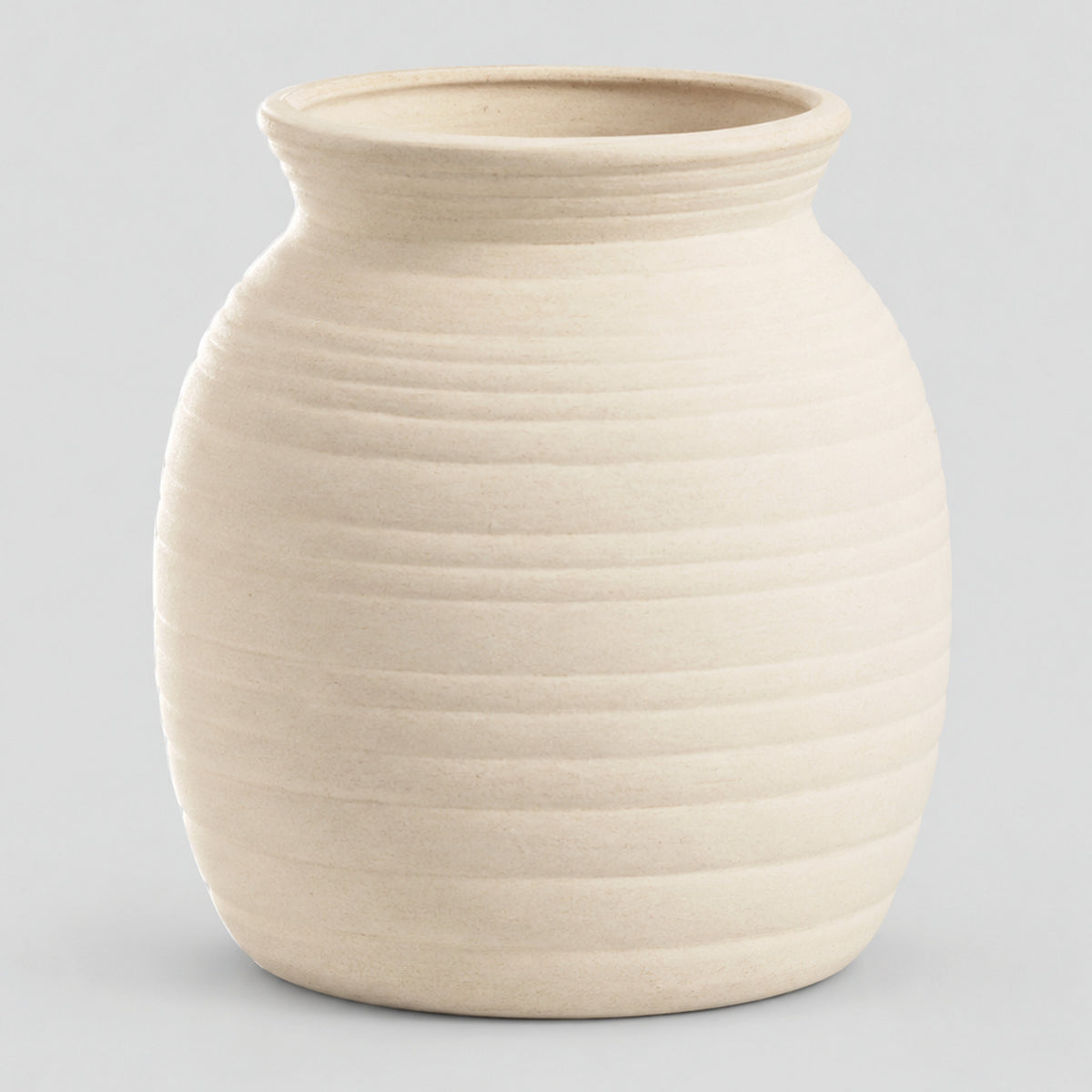 Off-white horizontally ribbed ceramic jar vase on a light gray studio background.