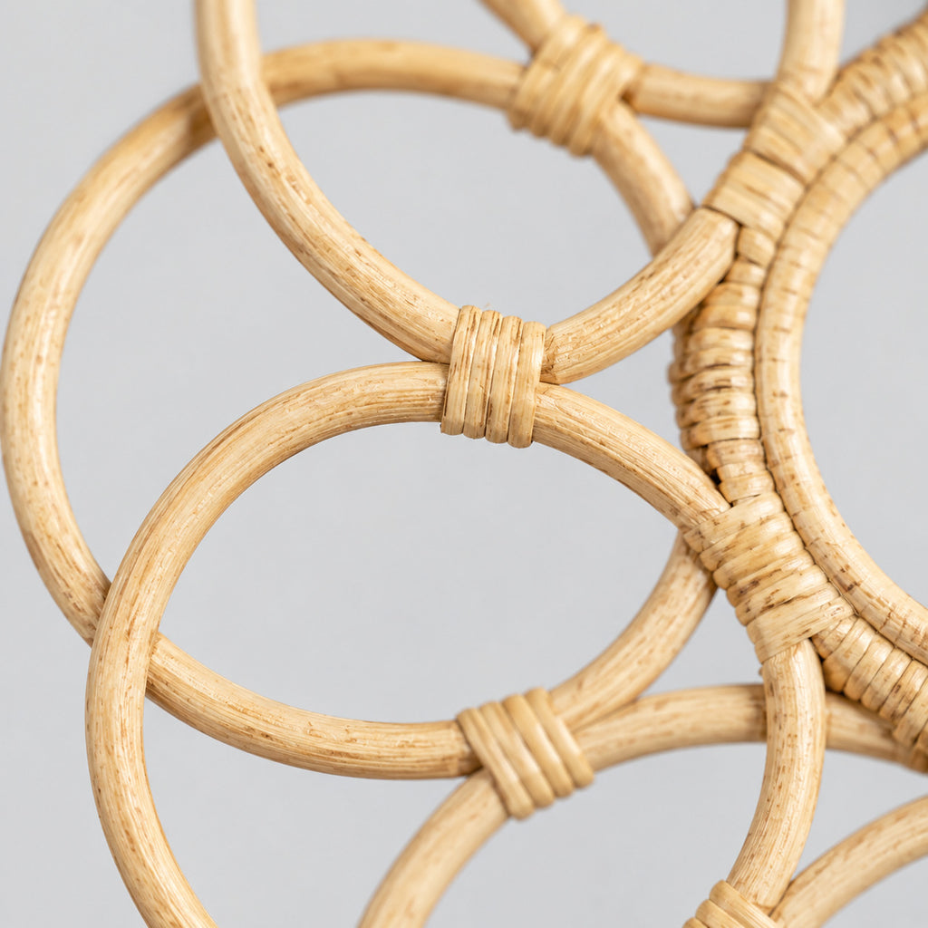 Close up of the wrapped cane joints connecting the outer loops of the decorative looped rattan wall frame in Natural Rattan.