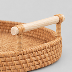 Close up of the smooth wood handle with wrapped rattan bindings of the Natural Rattan serving tray.