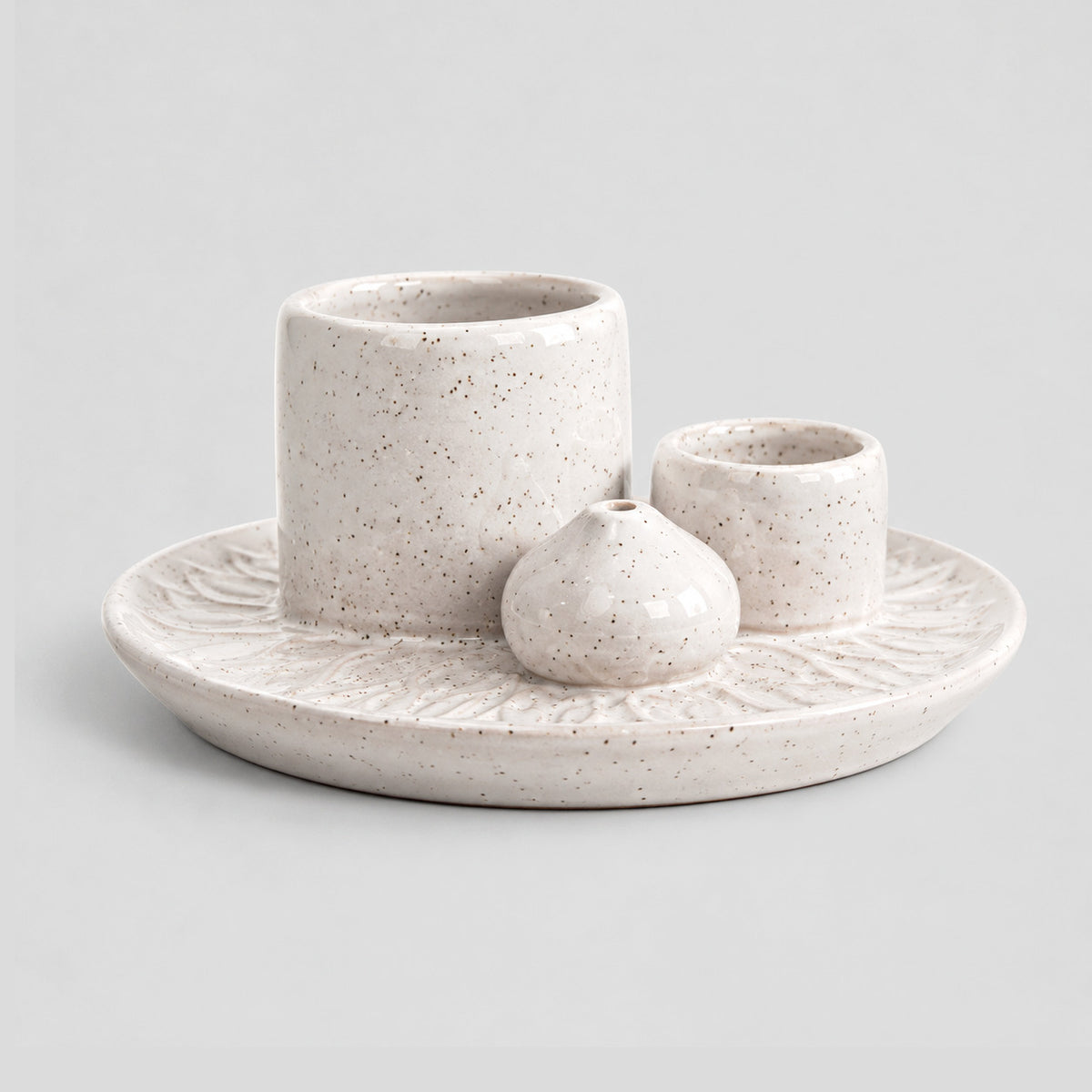 Speckled White ceramic incense dish on a light gray studio background