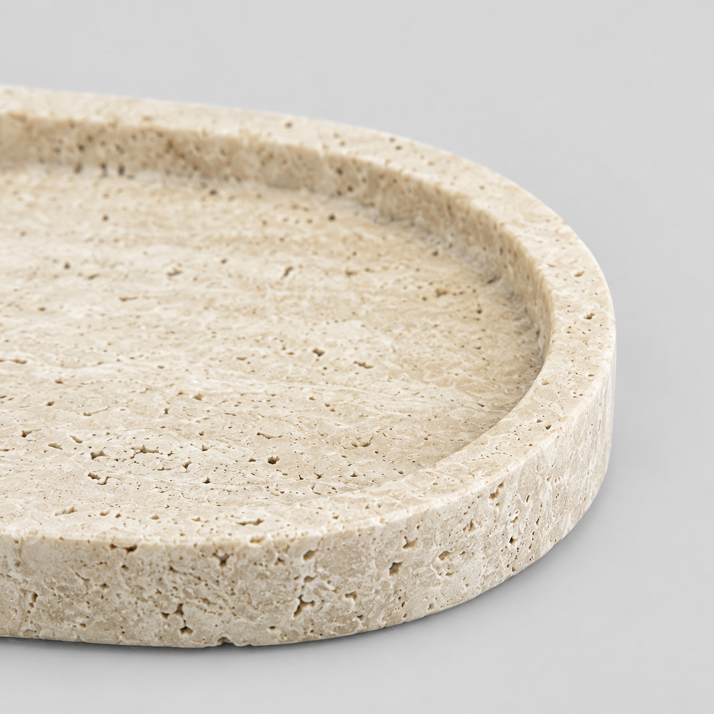 Close up of the shallow carved rim of the oval stone vanity tray in Beige Travertine