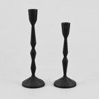 Set of two faceted cast iron taper candle holders in Matte Black on a light gray studio background