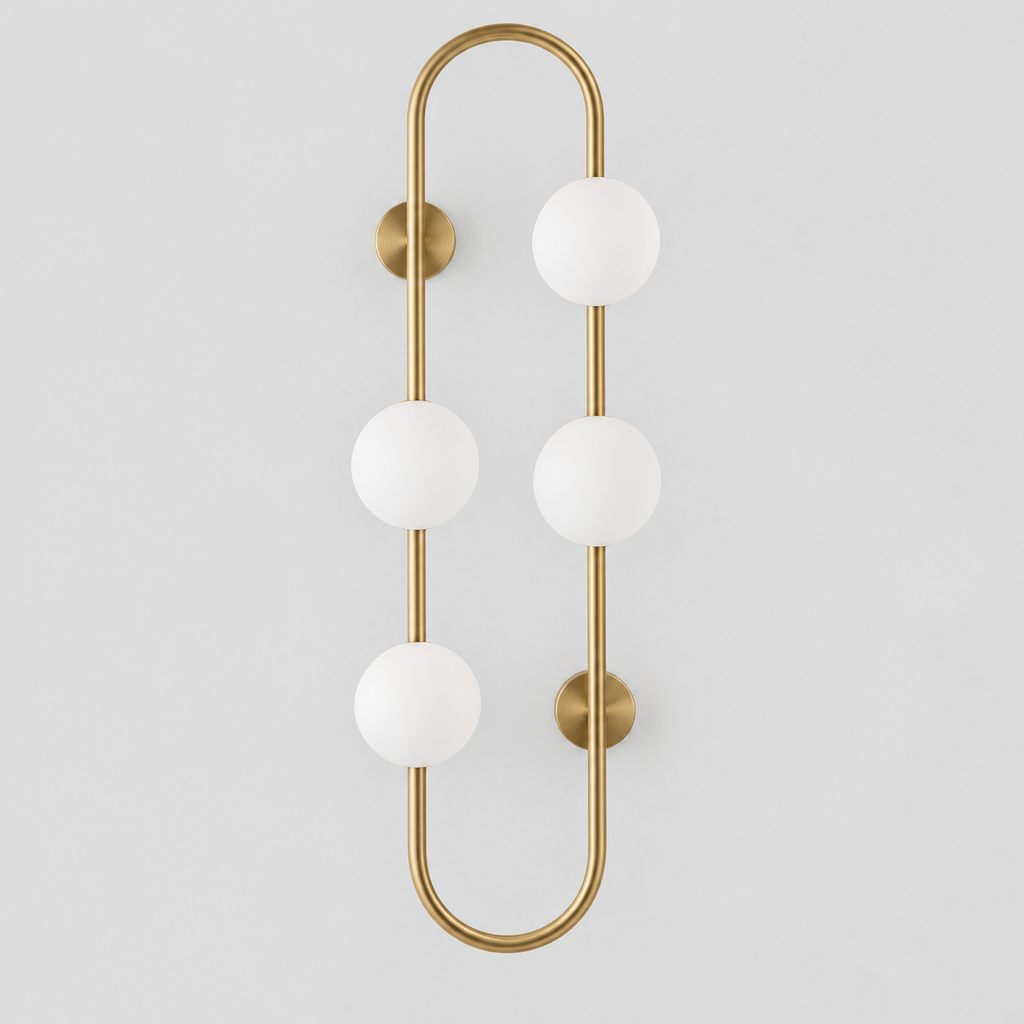 Brass pill-frame frosted globe wall sconce on a light gray studio background.