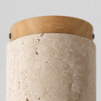 Close up of the round canopy against the wall of the cylindrical travertine ceiling light.