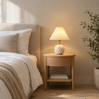 Fluted ceramic table lamp in Milk White lit standing on a 48 cm wide oak bedside table against a plain wall