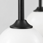 Close up of the finish at a seam of the metal body of the Matte Black asymmetric double-globe arch wall sconce.