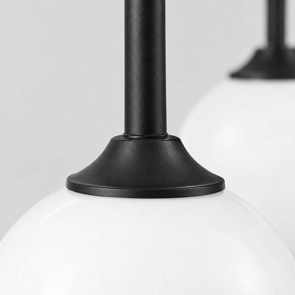 Close up of the finish at a seam of the metal body of the Matte Black asymmetric double-globe arch wall sconce.