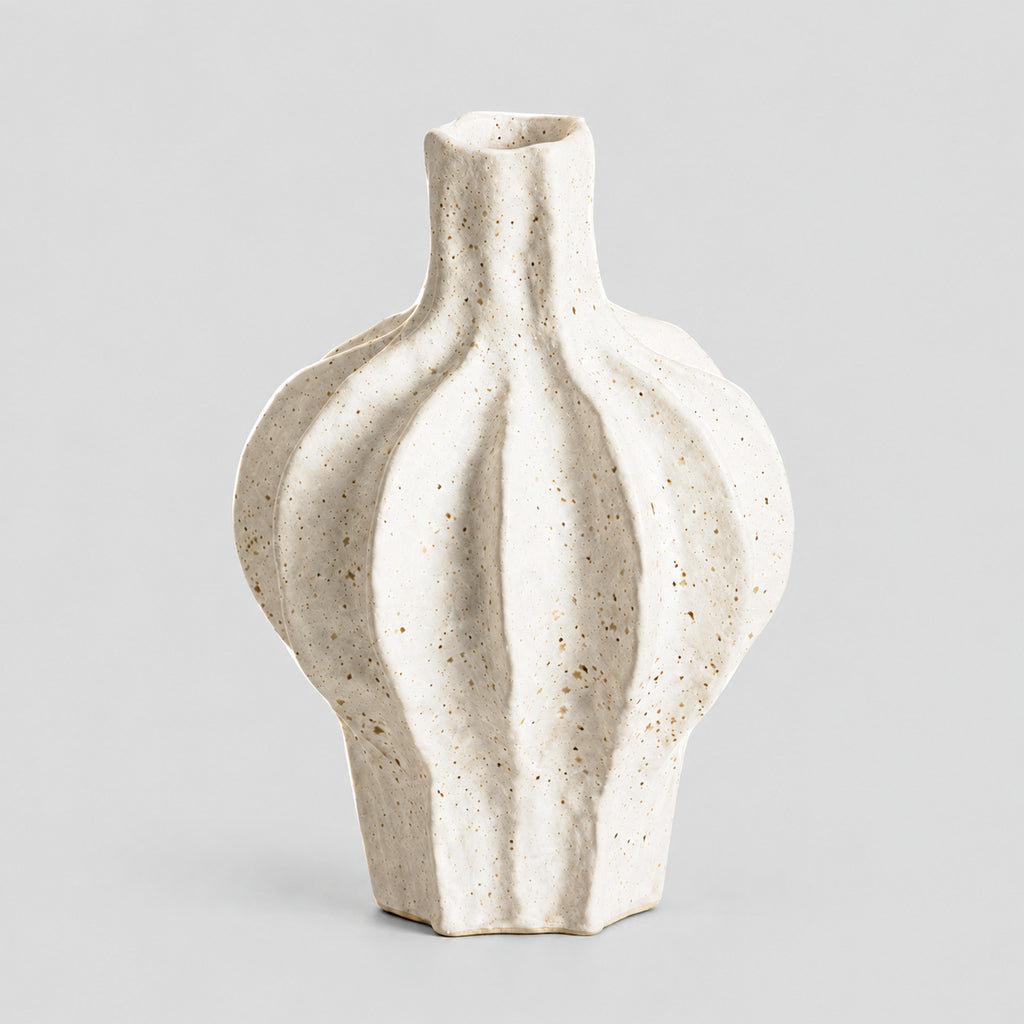 Coarse ceramic fluted vase in Speckled White on a light gray studio background, in its Large Fluted shape