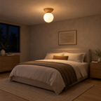 Natural wood flush mount ceiling light lit in the evening on the ceiling of a bedroom above a 160 cm wide made bed, the only light in the room.