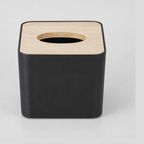 Black square tissue box cover with a natural wood lid on a light gray studio background.