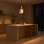 Travertine pendant light lit in the evening hanging above a kitchen island, the only light in the room