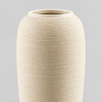 Close up of the brushed horizontal ribbed texture of the stoneware body of the off-white tall ribbed stoneware vase.