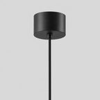 Close up of the round canopy against the wall of the Matte Black slender teardrop pendant light.