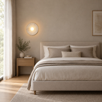 Distressed White circular concentric ripple wall sconce lit beside a 150 cm wide double bed against a plain wall.