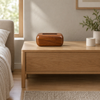 Curved solid wood tissue box cover in Walnut on a 48 cm wide oak bedside table in a calm bedroom.