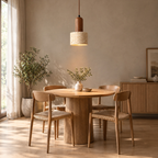 Yellow travertine pendant light lit hanging above a 90 cm round oak dining table in a daylight room.