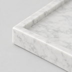 Close up of the raised stone rim of the rectangular marble vanity tray in Carrara White