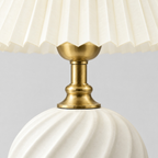 Close up of the brass socket cup holding the bulb seen from the side on the Milk White fluted ceramic table lamp