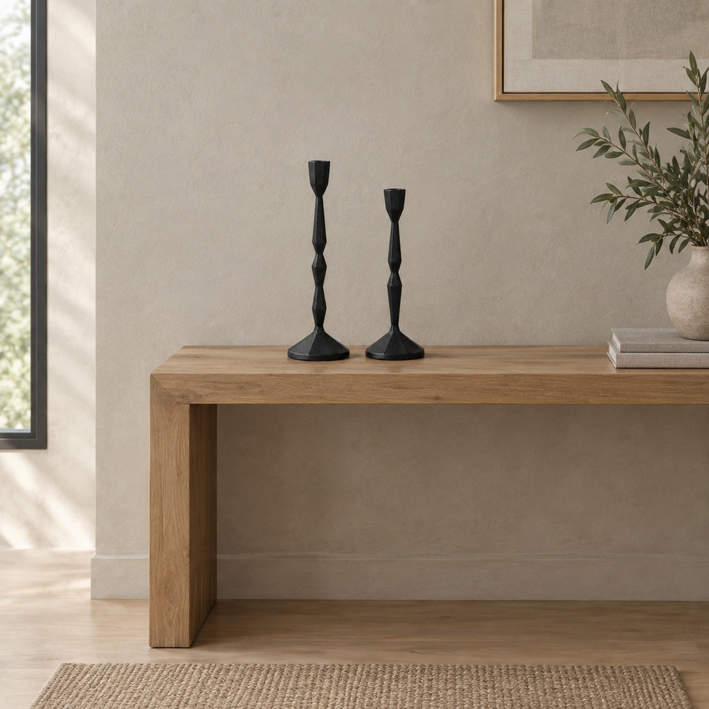 Set of two faceted cast iron taper candle holders in Matte Black on a 120 cm wide oak console table in a calm room