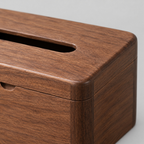 Close up of the smooth rounded rim of the hinged lid of the solid walnut tissue box.