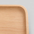 Close up of the gently raised rounded rim of the natural beech wood rounded square serving tray