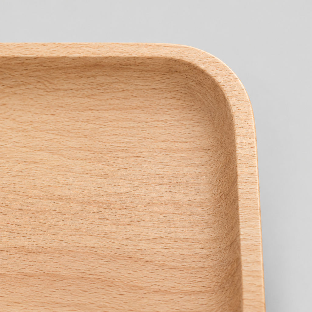 Close up of the gently raised rounded rim of the natural beech wood rounded square serving tray