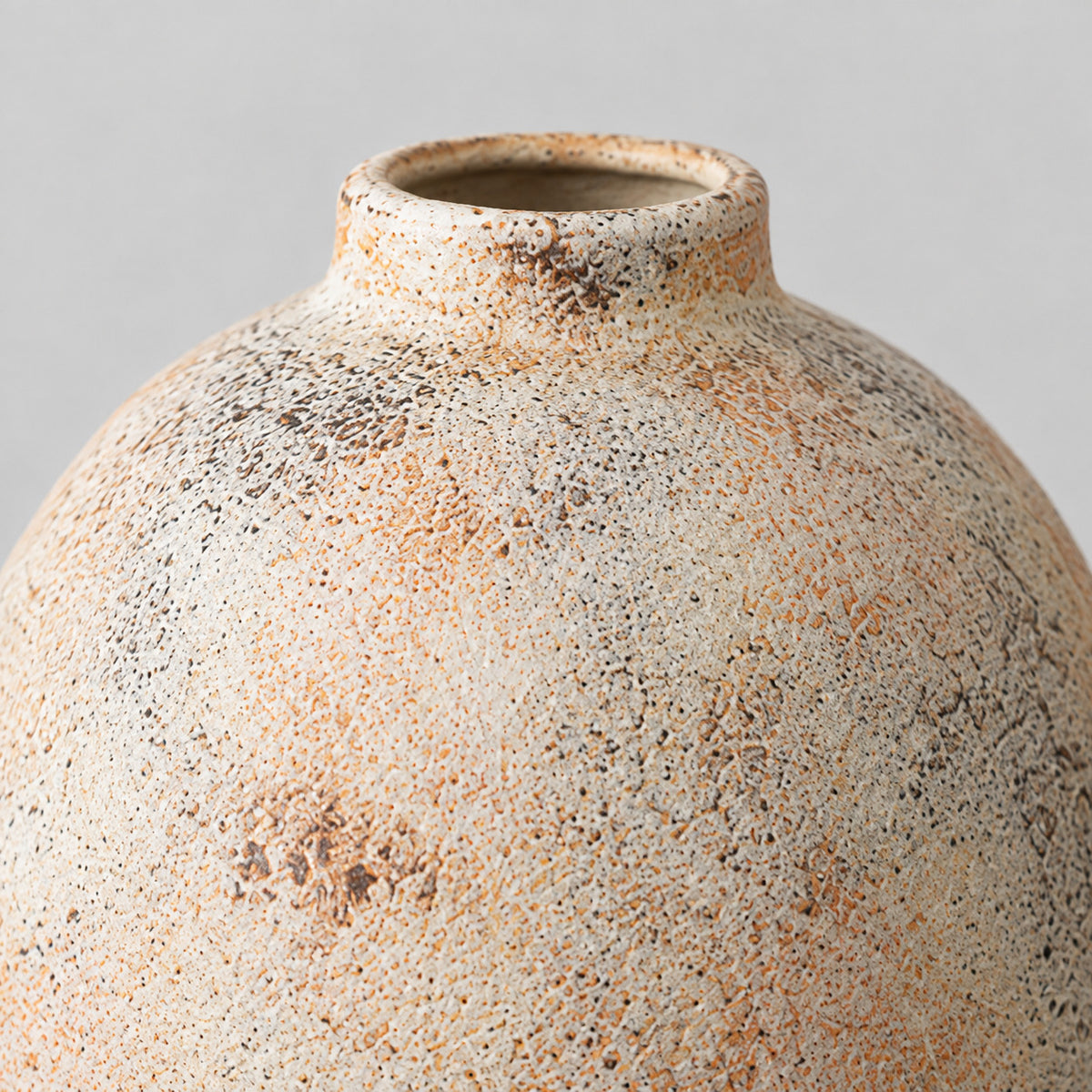Close up of the textured matte glaze with warm speckling of the ceramic vase.