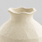 Close up of the ruffled rim of the textured ceramic vase in Cream.