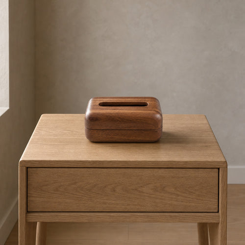 Rounded rectangular wooden tissue box cover in Walnut on a 48 cm wide oak bedside table in a calm room.